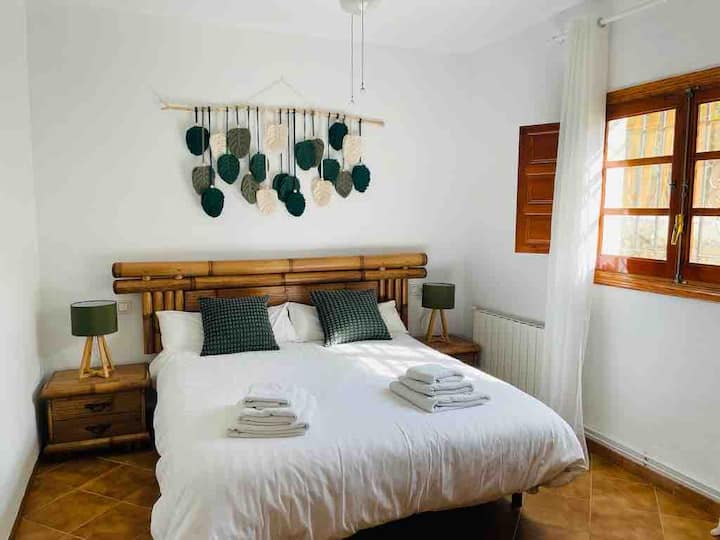Esta segunda habitación tiene un estilo único porque el macrame ha sido hecho a petición y  por un artista local y la cama de bambú.
La cama es de 160x200. La cama y el colchón son de 2023 desde Pikolin. Un ventilador de techo aporta aire fresco.