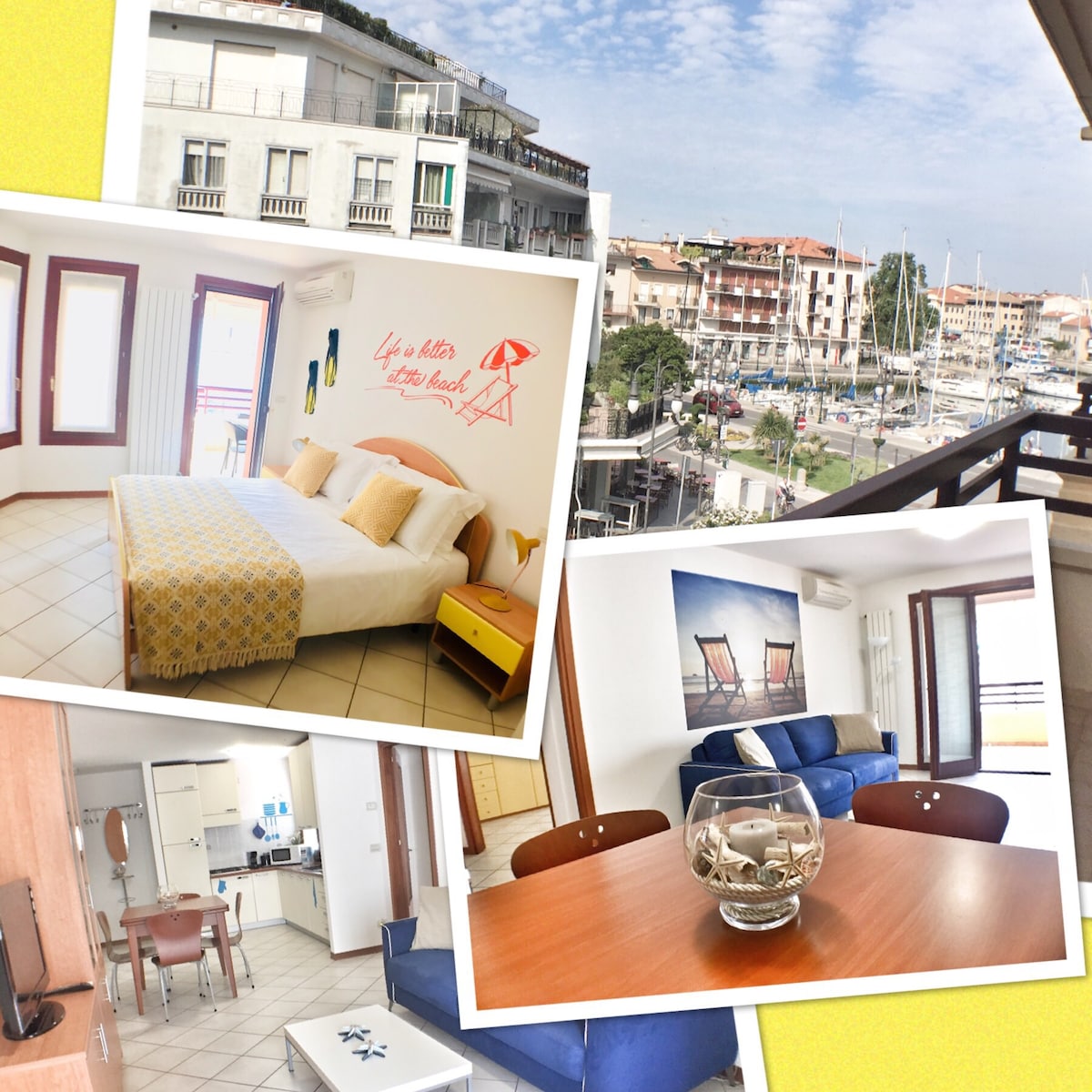 A bright studio room features a spacious bed with yellow accents against a backdrop of large windows. The living area showcases comfortable blue furniture and a wooden table. A view of the marina and boats is visible from the balcony, enhancing the inviting atmosphere of the space.