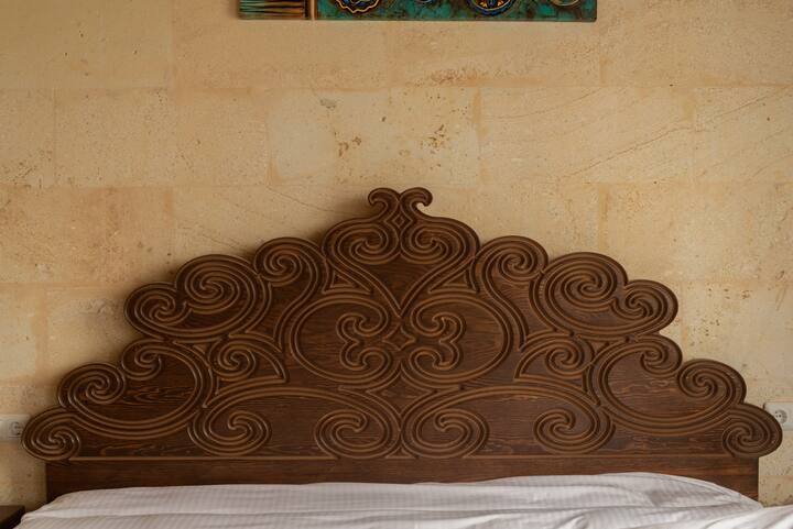 Detail of the hand carved wooden bed headboard