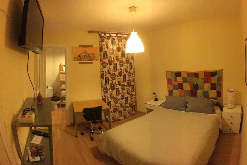 Habitación dormitorio, con escritorio y TV. A la izquierda el baño y a la derecha armario vestidor.