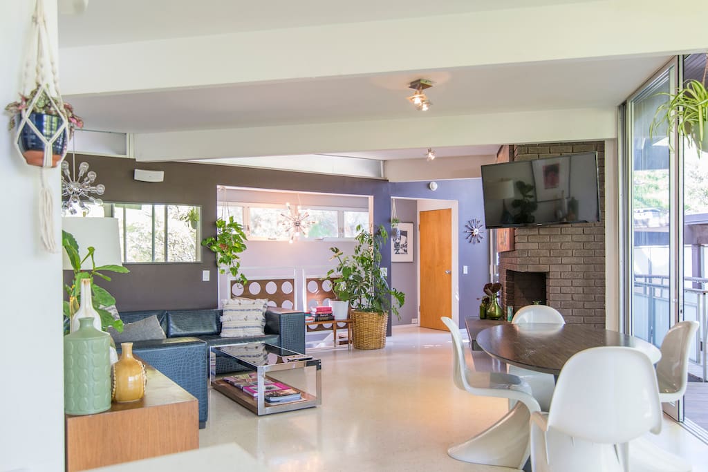 Gorgeous living room that comes alive with plants galore, gorgeous books and endless sunshine through those windows