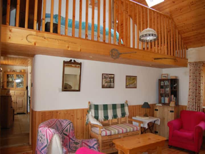 Doagh Cottage ‘sleeping loft’ with single bed over living room, showing door into kitchen (left) 