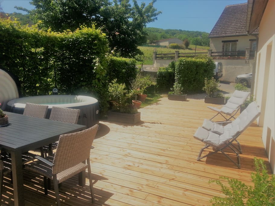 Vaste terrasse en bois en bordure du jardin.