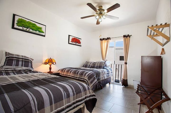 חדר שינה למעלה עם מיטה זוגית ומיטת יחיד, עם חדר רחצה ושירותים ומרפסת נחמדה.