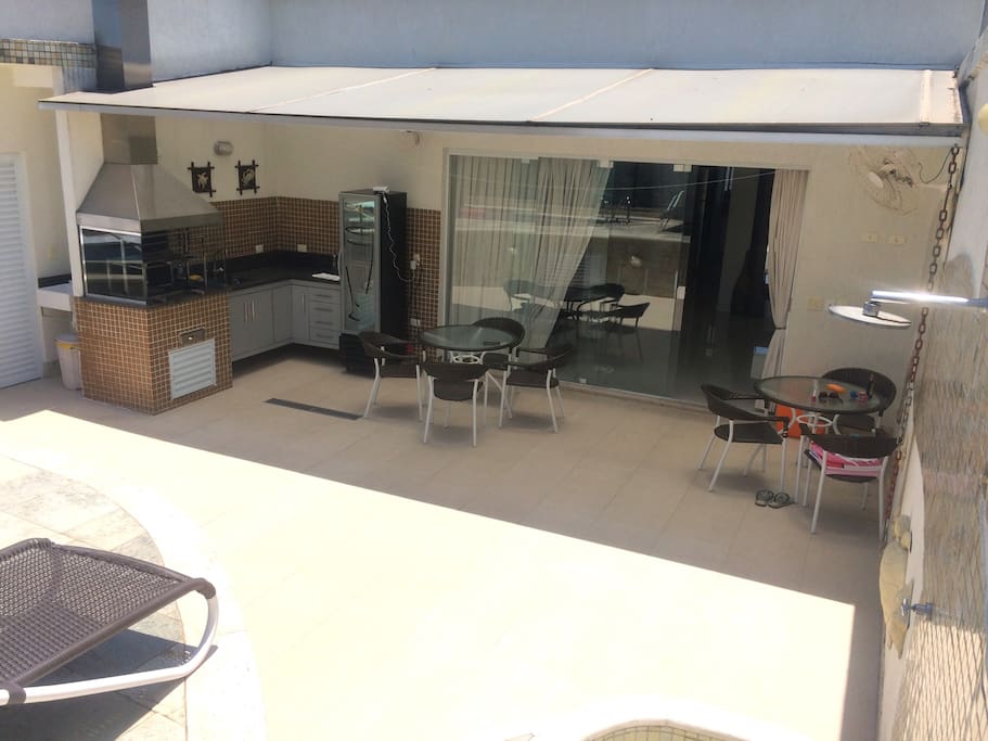 Varanda com churraqueira e banheiro externo com som ambiente