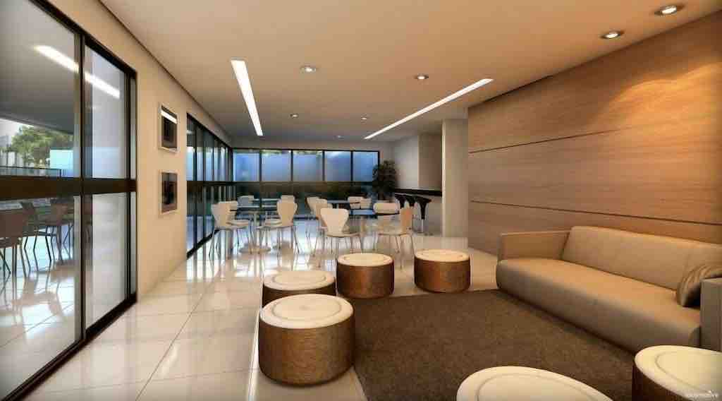A bright common area features large windows that allow natural light to fill the space. Comfortable seating is provided by a spacious sofa and circular stools. A dining area with white chairs and tables is visible in the background, creating an inviting atmosphere for gathering.