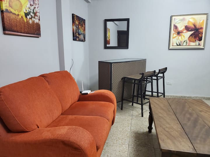 Всекидневна с кът за хранене, маса и минибар с 2 високи стола. 