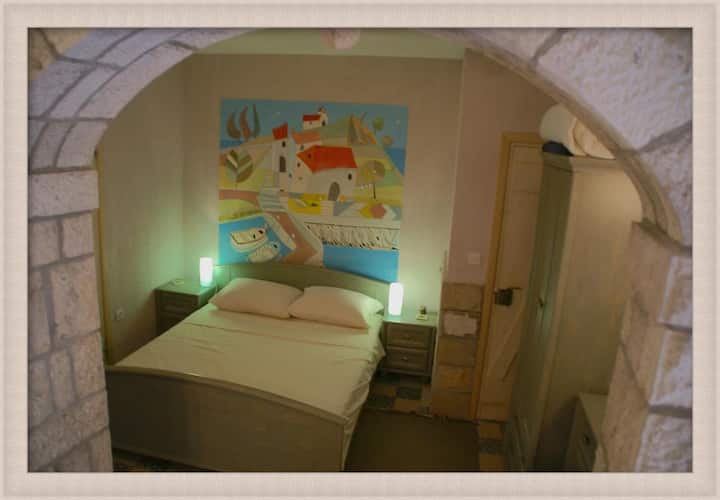 Kitanda kilicho na bafu upande wa kushoto. Ubao wa kikombe na kifua cha droo upande wa kulia. Pia kuna mlango unaoingiliana (uliofungwa) ikiwa ungependa pia kuweka nafasi kwenye nyumba. Mlango unaweza kufunguliwa kwa ajili ya kuingia kwenye nyumba na studio