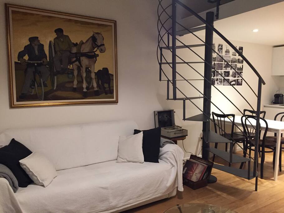 Divano per relax che si trasforma in letto matrimoniale e scala che porta nella camera da letto in soppalco