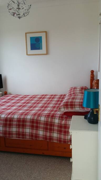 Bedside table with 3 drawer storage. Lamp and alarm clock.