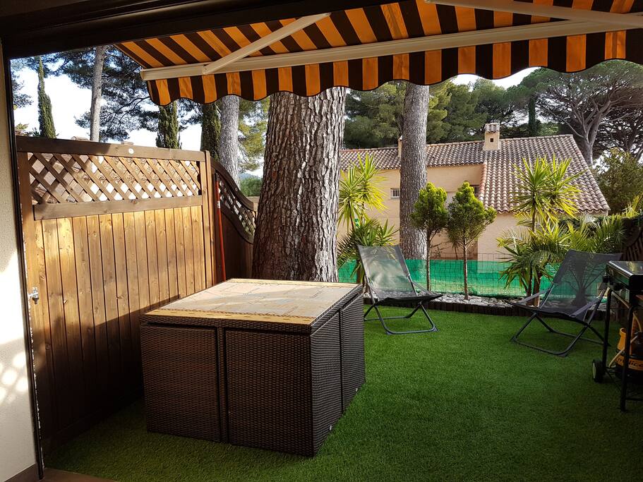 terasse de 15 m2 avec sont store et sa table de jardin et ses 4 fauteuils encastrés avec coussins