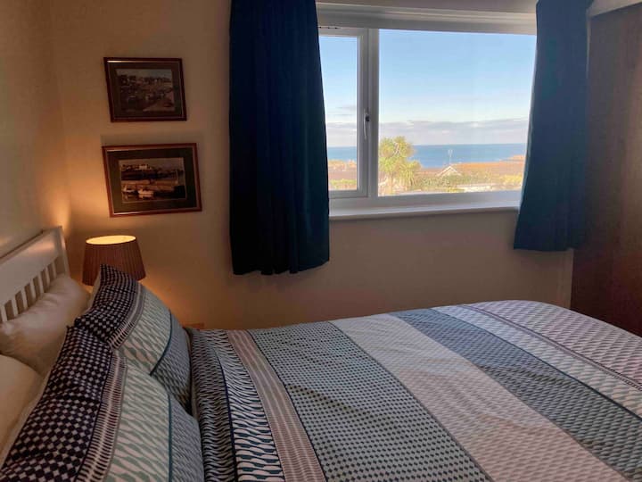 غرفة نوم رئيسية بسرير بحجم كينج وإطلالة على المحيط. خزانة ملابس كبيرة مدمجة مع قضيب ورفوف. خزانة منفصلة ذات أدراج. ستارة تعتيم. 