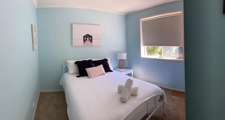 Coastal vibes bedroom with double bed and built in wardrobe.  