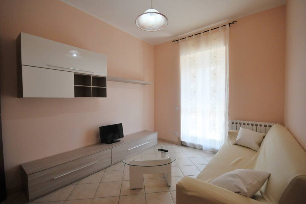 Salotto luminoso con tv e comodo divano letto.