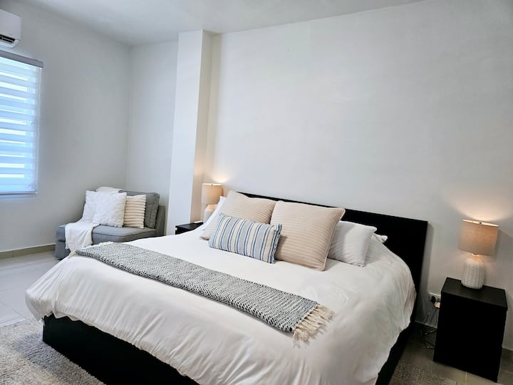 Spacious master bedroom with an arm chair that is convertible into a single bed for a kid 