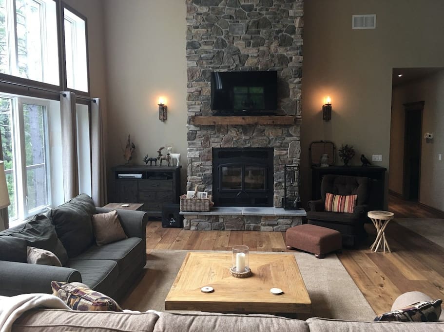 Floor-to-ceiling stone fireplace enhances the rustic ambience.