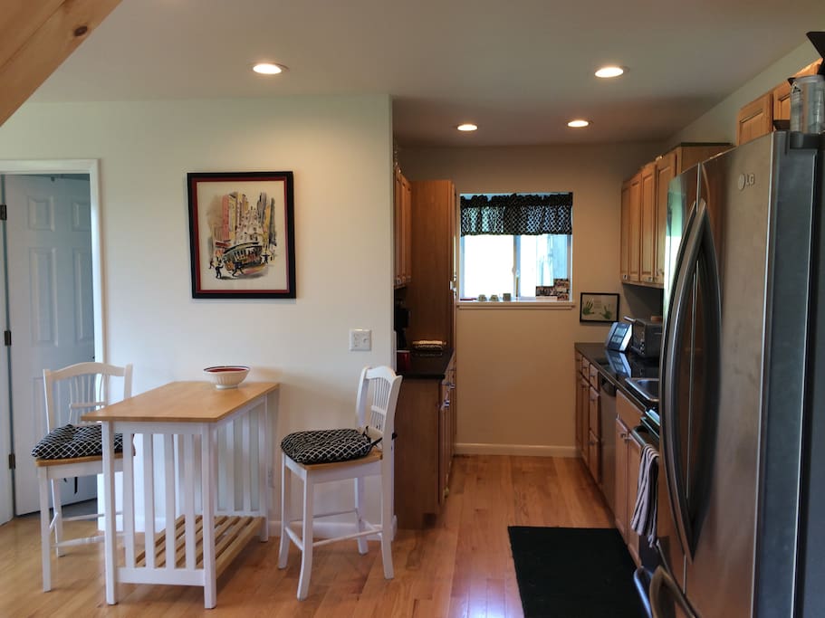 Kitchen complete with stove, refrigerator/freezer, microwave and dishwasher. Full size expandable table as well as a country table and stools.