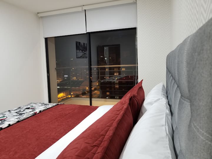 1 dormitorio con balcón con cama tamaño king.