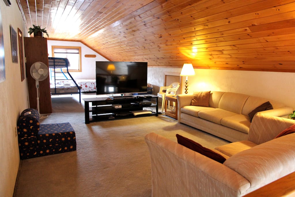 60" TV in loft. Single and bunk bed beyond.