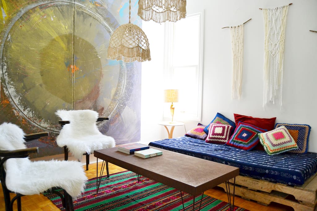 Filled with original art and eclectic mix of bohemian treasures, our living room is a comfy place to hangout during the day and at night the cushion filled sofa turns in to a third bed.