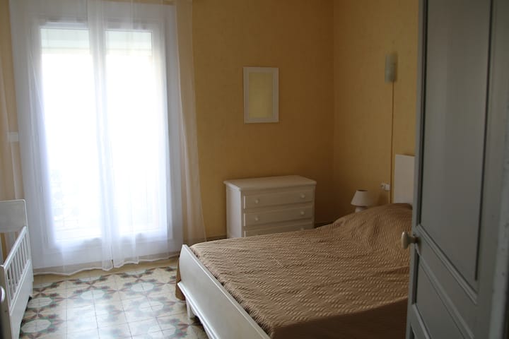 带婴儿床的卧室，有阳台 