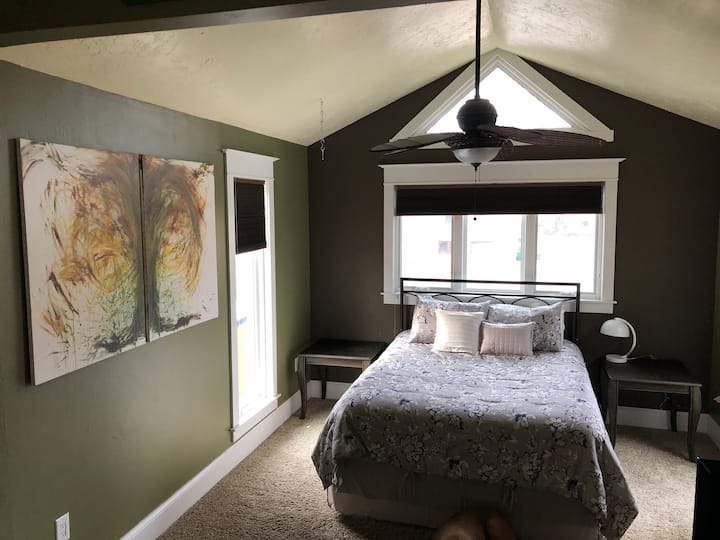 ห้องนอน 1 ที่มีเพดานโค้งและห้องนอนแบบขั้นบันไดพร้อมเตียงขนาดควีนไซส์