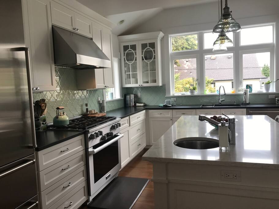 Cook's paradise featuring Miele six-burner range, SubZero fridge, large center island with prep sink and gadgets galore.