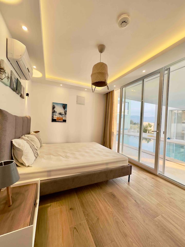 „Светла спалня с голямо легло, директен достъп до басейна и самостоятелна баня – идеална за почивка.“