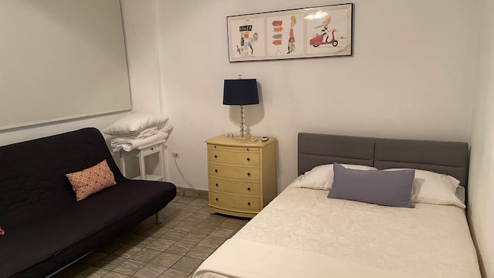 Första sovrummet. En dubbelsäng och två sängar i full storlek som rymmer 5 personer med celing-fläkt och luftkonditionering.