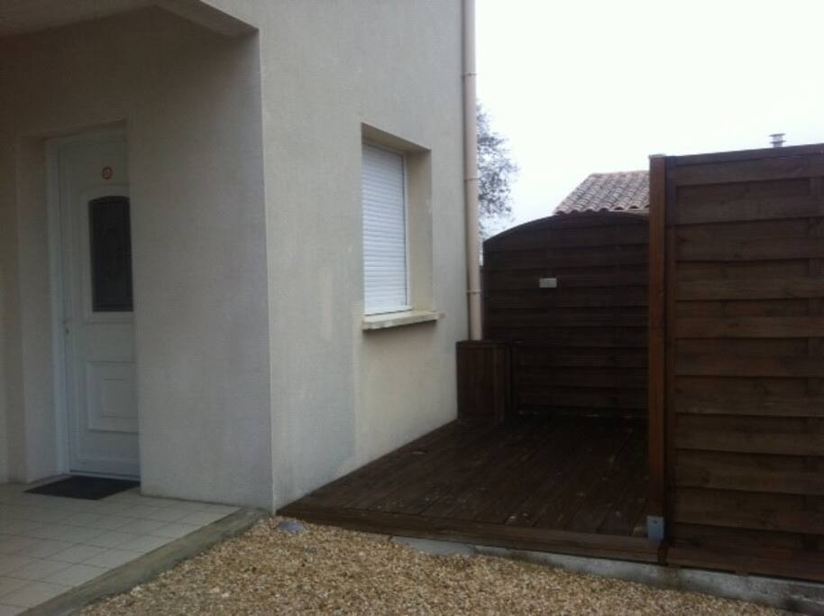 Entrée de l'appartement et la terrasse avec salon de jardin et barbecue