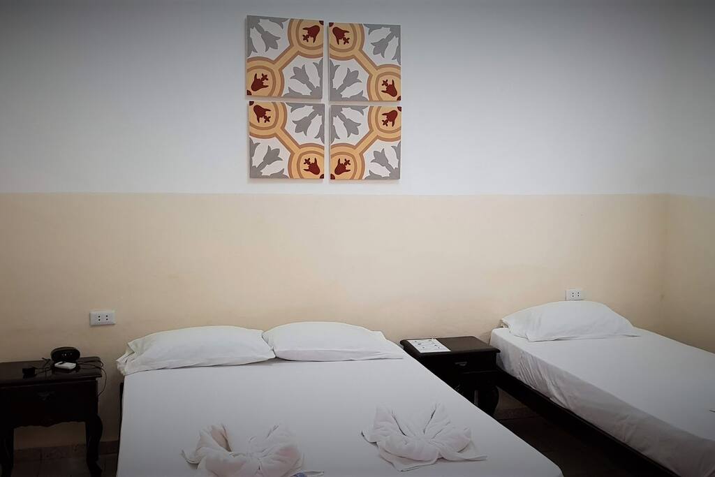 Your bedroom - with one queen bed, one single bed, split-system airconditioner and an attached bathroom