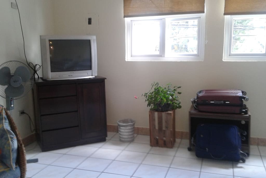 habitación con tv, espaciosa dos ventanas que proporcionan ventilación y entrada de luz, cajon para ropa, ventilador, dos sillas cómodas