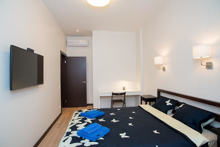 Dos acogedores y elegantes dormitorios con camas dobles tamaño king, TV inteligente de pantalla plana de 42 pulgadas con 100 canales de televisión internacionales, lugar de trabajo y lugar de almacenamiento de ropa, así como aire acondicionado con control remoto.