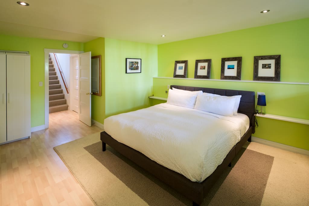 Bedroom with king bed and stairs leading back up to the main level