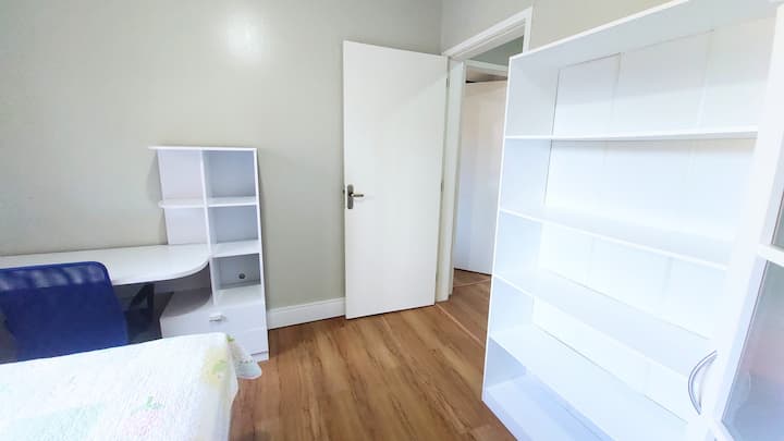 quarto com cama casal,  escrivaninha com cadeira e roupeiro.