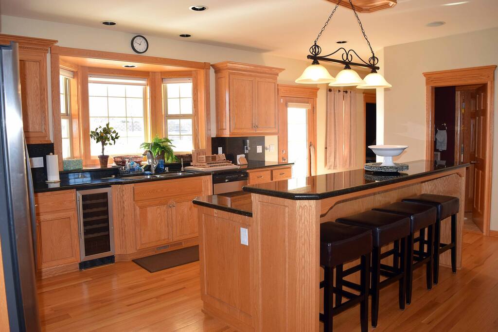 Large kitchen with all wood floors and granite counter tops with breakfast bar and fully stock cooking supplies