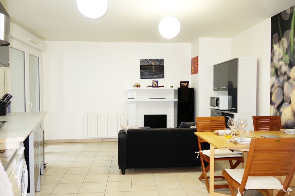 Espace cuisine - salon partagés / Porte-fenêtre sur terrasse fermée donnant sur jardin d'ornement / Canapé / télévision / Table pouvant servir de bureau si besoin / Wifi à disposition / Machine à Laver et à sécher / Lave vaisselle / Micro-onde / Plaque de cuisson à induction / Ustensiles de cuisine et couverts à disposition