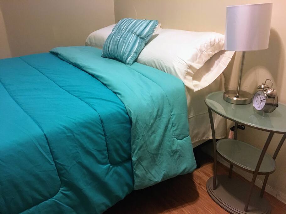One of two pillow top mattresses, covered in fresh linen. Reading lamp with USB charging port & alarm clock.