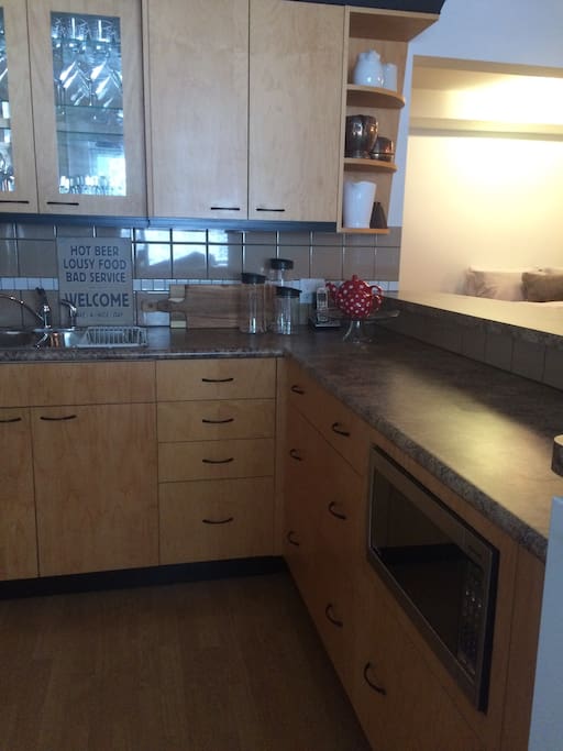 Kitchen is equipped with dishes, pots and pans.