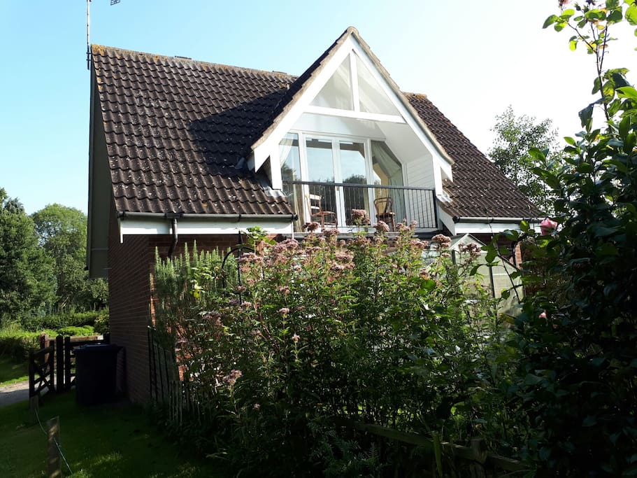Rear view of Alderfen lodge with south facing balcony overlooking surrounding farmland and mature trees.