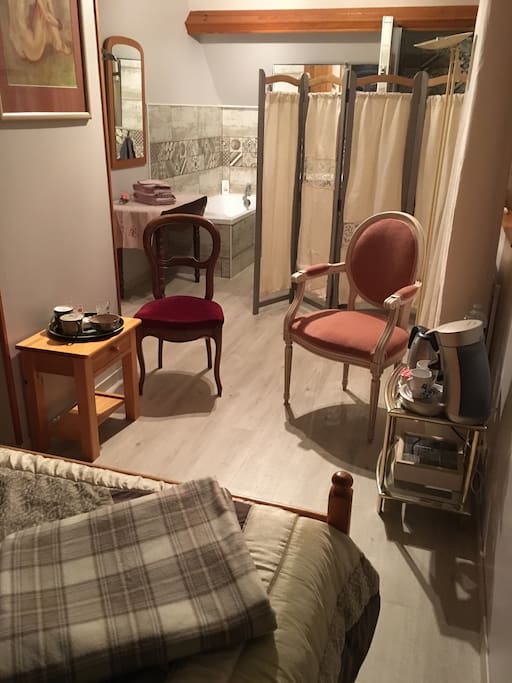 Entre-deux, offrant un coin café, thé et tisanes. Fauteuil confortable et chaise pour regarder la télé ou bouquiner.