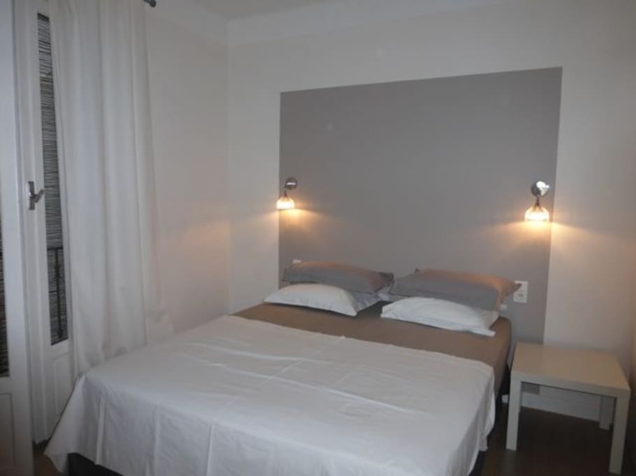 Chambre avec grand lit deux places et un lit en hauteur pour enfant.