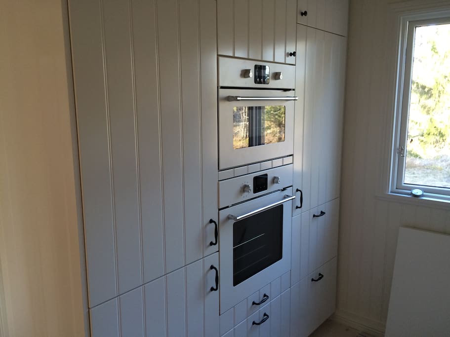 Modern kitchen with dishwasher, oven, microwave, glass cooktop, freezer, refrigerator