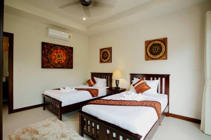 Bedroom 3 with 2 x single beds, air conditioning , ceiling fan and en-suite bathroom