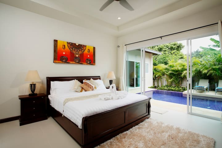 Bedroom 2 with king size bed, and sliding door access to swimming pool and sundeck