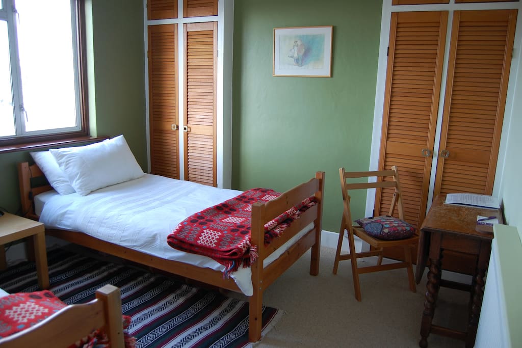 Twin room with table, chair, wardrobe.