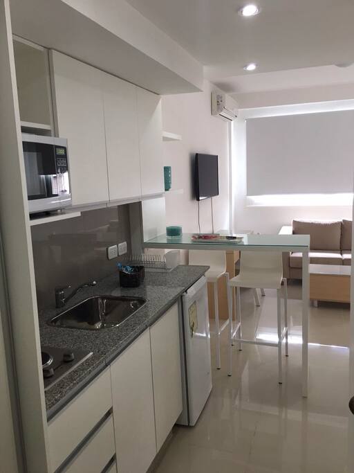 Cocina con microondas, heladera, vajilla nueva, jarra eléctrica, tostadora.