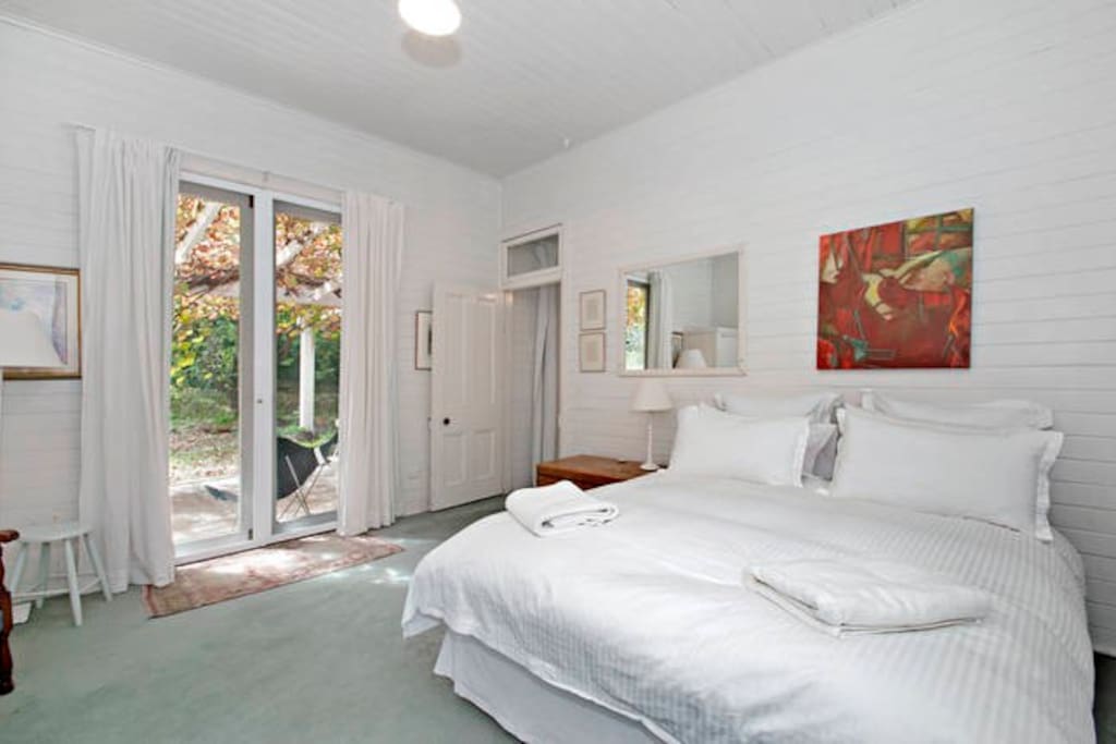 The spacious main bed, dressed with crisp linen