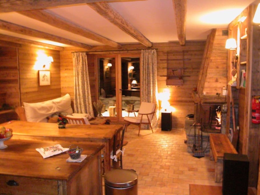 Salle de séjour rez de jardin la nuit cheminée