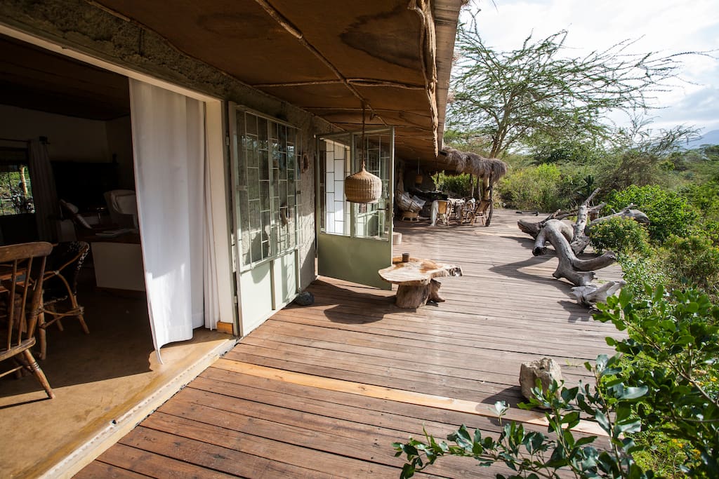 Spacious balcony, surrounded by dense African vegetation (acacia trees, bushes,...)
